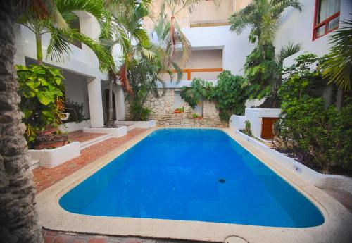 einem Pool in der Mitte eines Innenhofs mit einem Gebäude in der Unterkunft Hotel Carrillos Cancun in Cancún