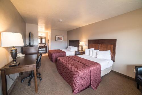 a hotel room with two beds and a desk at Red Ledges Inn in Tropic