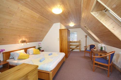 a bedroom with a large bed and a wooden ceiling at Pension Harrachov in Harrachov