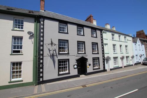 a row of white buildings on the side of a street at The Beacons Guest House in Brecon