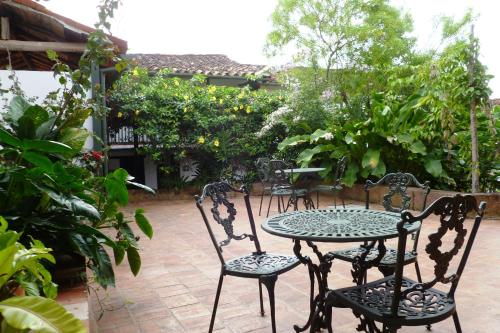 a patio with a table and chairs in a garden at Hotel Mision Santa Barbara RNT 4799 in Barichara