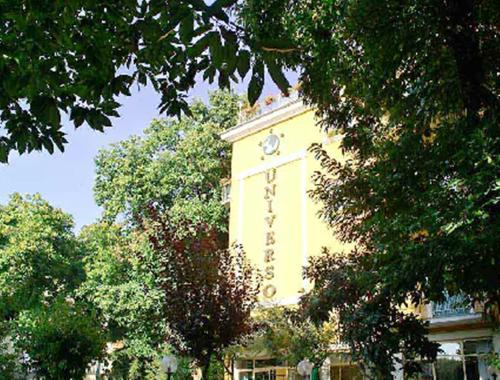 ein Gebäude mit einem Uhrturm inmitten von Bäumen in der Unterkunft Hotel Universo in Fiuggi