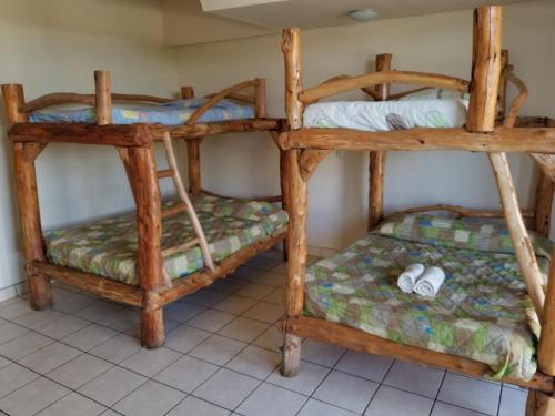 two bunk beds in a room with a tiled floor at Hotel Monte Campana Heredia in Birrí