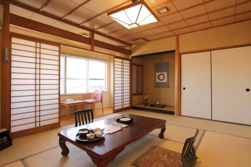 a dining room with a table and chairs and a room at Ryokan Oomuraya in Ureshino