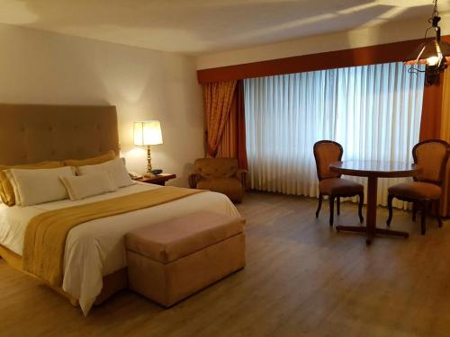 a hotel room with a bed and a table and chairs at Antara Hotel & Suites - Miraflores in Lima