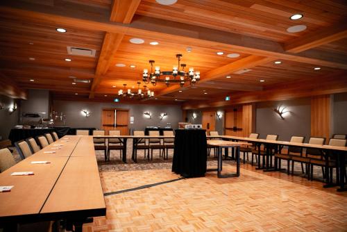 a dining room with tables and chairs and a chandelier at Moose Hotel and Suites in Banff