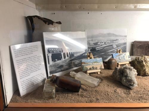 a display of glass bottles and pictures in a display case at Amargosa Opera House & Hotel in Death Valley Junction