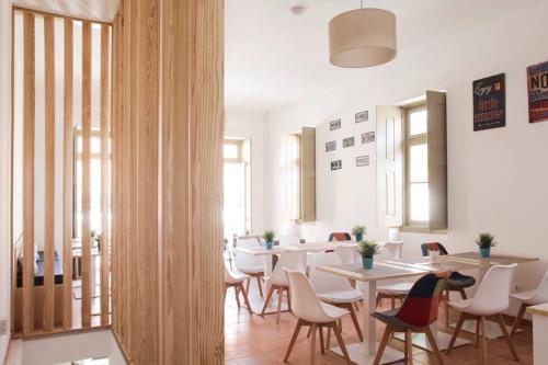 a restaurant with tables and chairs in a room at Águeda Hostel & Friends in Águeda