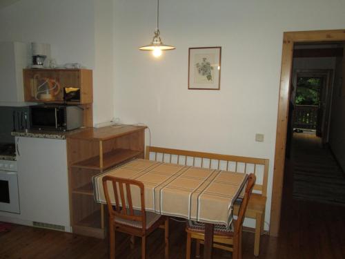 a kitchen with a table and a table and chairs at Schloss Manndorf Gästehaus in Kötschach