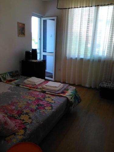 1 dormitorio con cama y ventana con cortina en Viki en Burgas