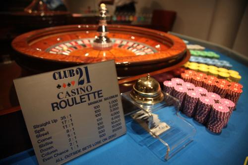 a table with a casino roulette sign and some cupcakes at The Melanesian Port Vila in Port Vila