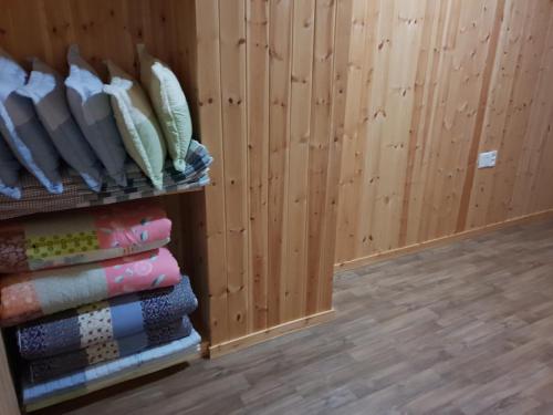 a room with wooden walls and a rack of pillows at Jirisan One Night Two Days Pension in Gurye