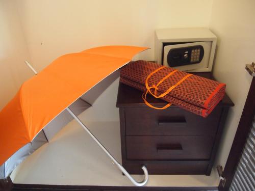 an orange umbrella standing next to a microwave at Summer Inn in Lamai