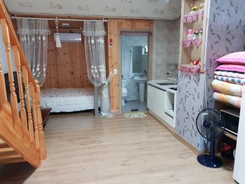 een badkamer met een bed en een wastafel in een kamer bij Jirisan One Night Two Days Pension in Gurye