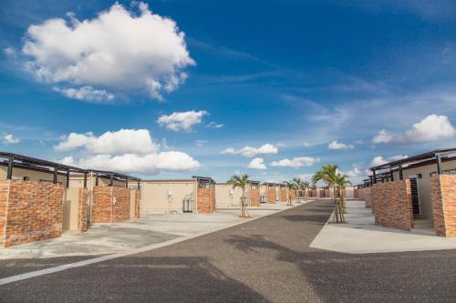 a row of buildings with palm trees and a blue sky at Villa Vorla in Miyako-jima