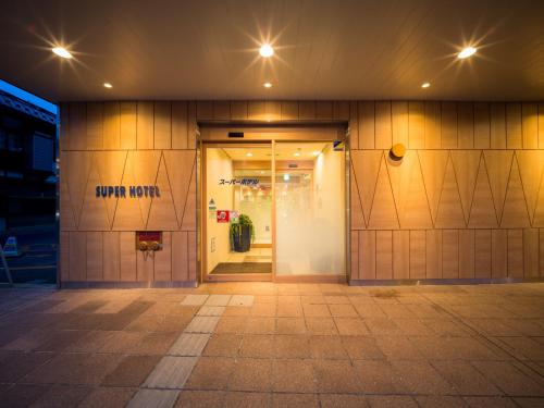 an entrance to a building with a sign on the door at Super Hotel Hirosaki in Hirosaki