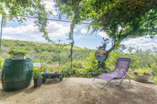 a purple chair and a table and some plants at House Green Paradise in Vrpolje