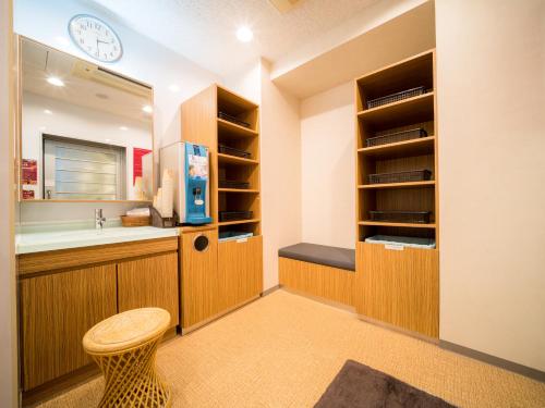 een badkamer met een wastafel, een toilet en een klok bij Super Hotel Hirosaki in Hirosaki