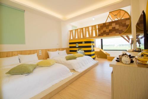 冬山鄉的住宿－梅花森林親子民宿，一间卧室设有两张床和一张高架床。