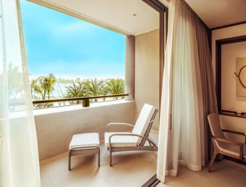 a balcony with chairs and a view of the ocean at Angsana Zhuhai Phoenix Bay in Zhuhai