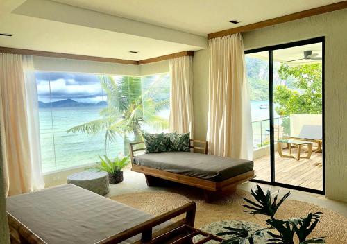 Schlafzimmer mit einem Bett und Meerblick in der Unterkunft Frangipani El Nido in El Nido