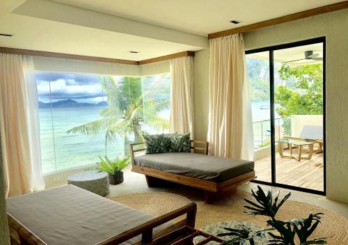 a bedroom with a bed and a view of the ocean at Frangipani El Nido in El Nido