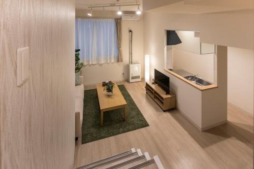 a living room with a table and a kitchen at PINN-N4E2Ⅰ in Sapporo