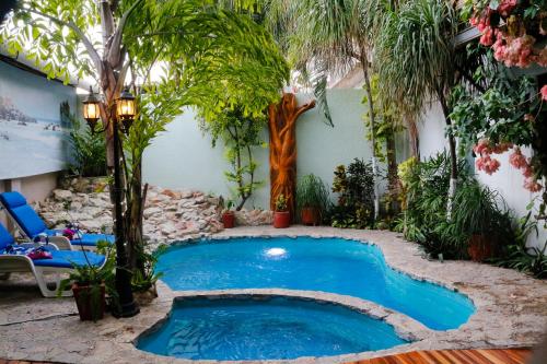 una piscina en medio de un patio con palmeras en Hotel Careyes Puerto Escondido, en Puerto Escondido