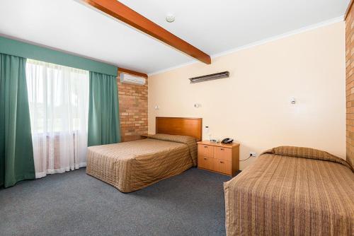 een slaapkamer met 2 bedden en een raam bij Cudgegong Valley Motel in Mudgee