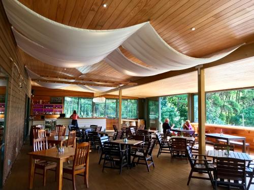 una sala da pranzo con tavoli, sedie e finestre di Tangiaro Retreat a Colville