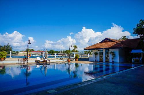 ein Pool neben einem Gebäude mit einem Gebäude in der Unterkunft Kudat Golf & Marina Resort in Kudat