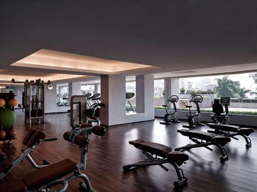 a gym with a bunch of exercise equipment in a room at Pullman Hanoi in Hanoi