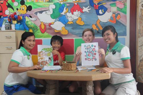a group of children sitting at a table with their paintings at Discovery Kartika Plaza Hotel in Kuta
