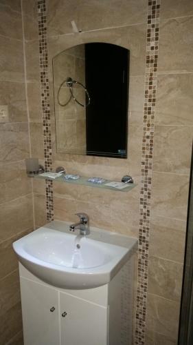 a bathroom with a sink and a mirror at Taai Hotel in Sozopol