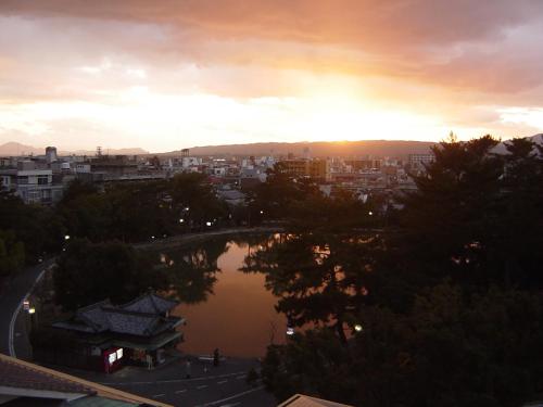 a view of a city at sunset with a lake at Ryokan Kousen Kazeya Group in Nara