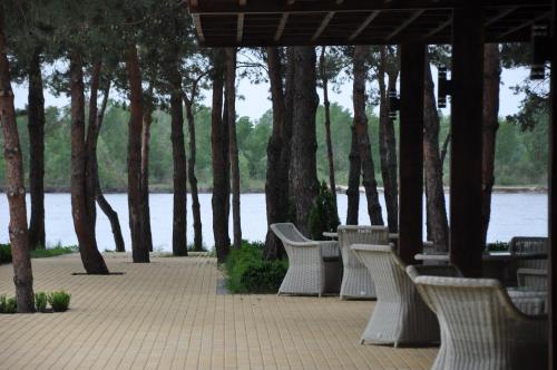 a row of white benches sitting next to a river at Park-Hotel Tihiy Les in Prokhorovka