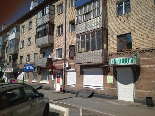 オレンブルクにあるApartment on prospekt Pobedyの正面に車を停めた路上の建物