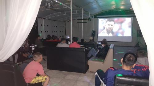 a group of people watching a movie on a screen at Bely Parus in Bosteri