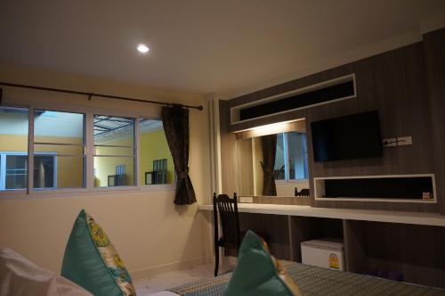 a living room with a tv and a window at Samsen Sam Place in Bangkok