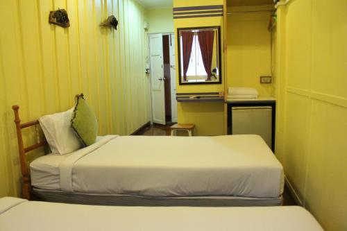 a small room with two beds and a mirror at Samsen Sam Place in Bangkok