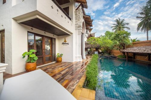 a villa with a swimming pool in front of a house at Shinnabhura Historic Boutique Hotel in Phitsanulok