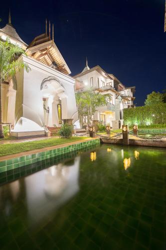 a house with a pool of water in front of it at Shinnabhura Historic Boutique Hotel in Phitsanulok