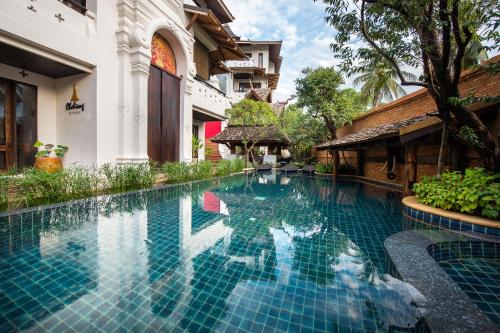 a swimming pool in front of a building at Shinnabhura Historic Boutique Hotel in Phitsanulok