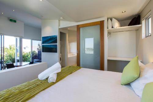 ein Schlafzimmer mit einem großen weißen Bett mit grünen Kissen in der Unterkunft Aquatic Visions Studio Apartments in Margaret River Town