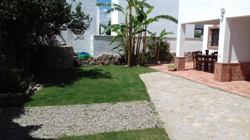a small yard with green grass and a house at La Aceitera de Trafalgar in Zahora