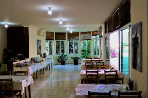un comedor con mesas, sillas y ventanas en Byblos Comfort Hotel, en Biblos