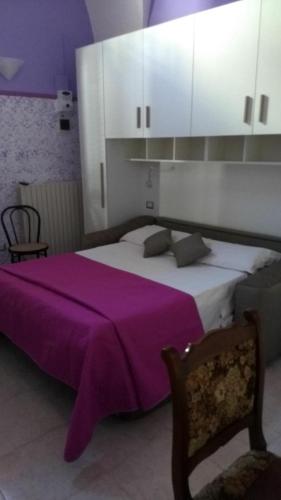 a bedroom with a large bed with a purple blanket at Vera Vacanza in Sannicola