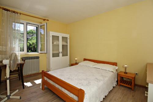 a bedroom with a bed and a desk and a window at Filipi Apartment in Sali