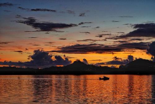 a boat on the water with a sunset at Ocean Star Hotel in Koror