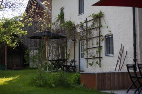 a house with a table and an umbrella in the yard at Zeitraumferien in Bernau am Chiemsee